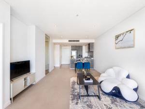 een woonkamer met een bank en een tv bij Amazing cityview Glamourous 2BR Apt w parkpool in Brisbane