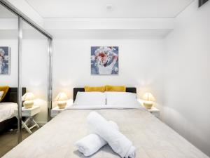 een slaapkamer met een groot bed met witte lakens bij Amazing cityview Glamourous 2BR Apt w parkpool in Brisbane