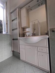 a white bathroom with a sink and a mirror at Casa Zia Luisa in Lecco