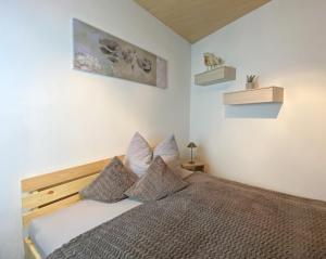 een slaapkamer met een bed met 2 kussens bij Ferienwohnung Jochum-Pfeiffer in Riezlern