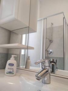 a bathroom sink with a mirror and a bottle of soap at Casa Zia Luisa in Lecco +47 photos