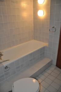 a bathroom with a toilet and a bath tub at Hostel KarMa in Gelsenkirchen