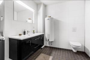 a white bathroom with a toilet and a sink at Modern 2-bedroom apartment 