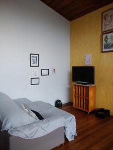 a bedroom with a bed and a flat screen tv at Solar Diamantina Apartamentos in Florianópolis