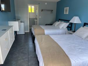 a hotel room with two beds and a bathroom at Seagrass Inn in Old Orchard Beach
