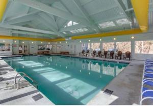 a large swimming pool with chairs in a building at Bryce Chalet Retreat A Mountain Getaway in Basye