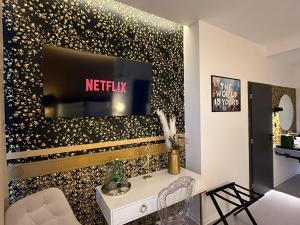 a living room with a tv on a wall with gold stars at Villa Mala Praha Experience in the Center of Žilina in Žilina