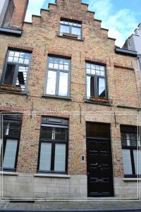 un edificio de ladrillo con ventanas y una puerta negra en Exclusive ground floor place near market square en Brujas