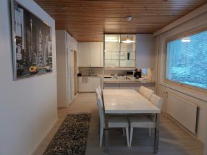 eine Küche mit einem Tisch und Stühlen sowie einem Fenster in der Unterkunft Suuri huoneisto isommalle ryhmälle / Large apartment for bigger group in Tampere