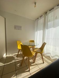 ein Esszimmer mit einem Glastisch und gelben Stühlen in der Unterkunft Hermoso departamento a pasos de avenida del mar in La Serena + 16 Fotos