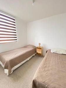 En eller flere senge i et værelse på Hermoso departamento a pasos de avenida del mar
