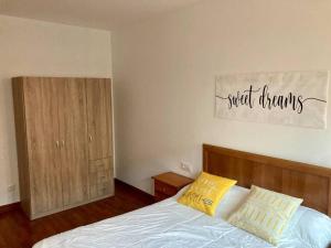 a bedroom with a bed with two yellow pillows at Apartamento con jardín y piscina temporada verano privados in Samieira