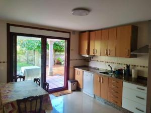 A kitchen or kitchenette at Apartamento con jardín y piscina temporada verano privados