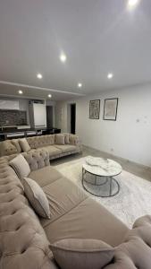 sala de estar amplia con sofá y mesa en Appartement avec jardinet, quartier pavillonnaire, en Argenteuil