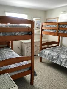 a bedroom with three bunk beds and a window at Pet Friendly Beach Front Vacation Rental On Lbi in Brant Beach