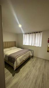 1 dormitorio con cama y ventana en Appartement avec jardinet, quartier pavillonnaire, en Argenteuil
