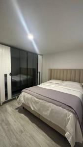 1 dormitorio con 1 cama grande y espejo en Appartement avec jardinet, quartier pavillonnaire, en Argenteuil