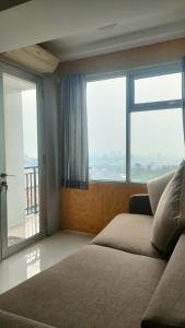 a bedroom with a bed and a large window at The jarddin apartment 2BR by kanaya in Bandung