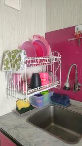 a kitchen sink with a dish drying rack above it at The jarddin apartment 2BR by kanaya in Bandung