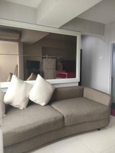 a couch with pillows on it in a living room at The jarddin apartment 2BR by kanaya in Bandung
