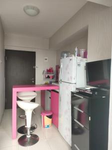 a kitchen with a pink counter and a refrigerator at The jarddin apartment 2BR by kanaya in Bandung