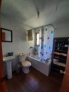 y baño con bañera, aseo y lavamanos. en Cabañas Rayen, en Riñinahue