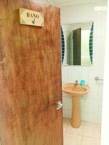 baño con puerta de madera y lavamanos en B&B Hogar Bella Vita, en Coquimbo