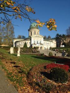 un gran edificio blanco con techo verde en Sasanka LZ en Lądek-Zdrój