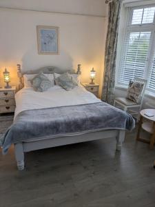 Un dormitorio con una cama grande con una manta. en The garden apartment en St Ives