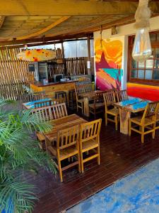 un restaurante con mesas de madera y sillas en un porche en Coral azul Noronha en Fernando de Noronha