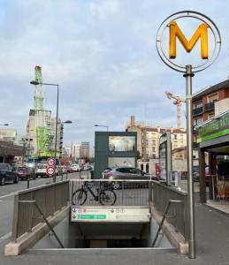 een m teken op een straat met een fiets op een brug bij Studio Émeraude au centre-ville in Villejuif