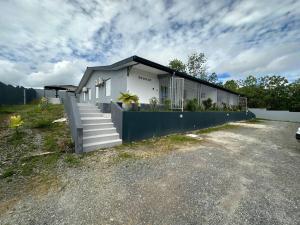a white house with a blue fence and stairs at SLM - Le clos Gaïac - A in Saint-Laurent du Maroni
