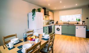 a kitchen with a table and a kitchen with a refrigerator at Contractor accom, sleeps 7, free wifi in Stockton-on-Tees