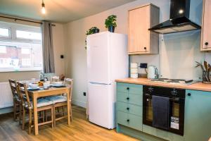 a kitchen with a table and a white refrigerator at Contractor accom, sleeps 7, free wifi in Stockton-on-Tees +23 photos