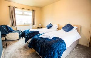 a bedroom with two beds and a chair and a window at Contractor accom, sleeps 7, free wifi in Stockton-on-Tees