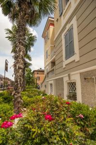 eine Palme und Blumen vor einem Gebäude in der Unterkunft Hotel Villa Maranello in Maranello