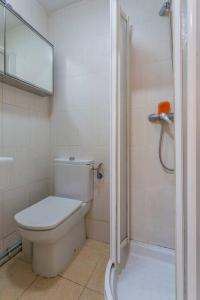 biała łazienka z toaletą i prysznicem w obiekcie Habitaciónes Luminosas y acogedoras w Madrycie