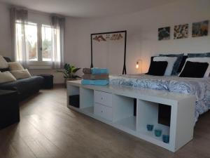 a bedroom with a white bed and a couch at La Tourelle Suite Cosy entre vignoble aixois et Luberon in Le Puy-Sainte-Réparade