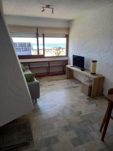 - un salon avec un canapé et un bureau avec une télévision dans l'établissement Apartamento Alberobello, à Punta del Este