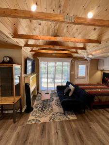 Sala de estar con cama, sofá y TV en The Lake Alfred Citruswood Cabin, en Lake Alfred