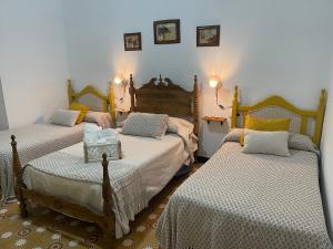 1 dormitorio con 3 camas y mesa. en Casa Muriana, en Alanís