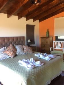 1 dormitorio con 1 cama con toallas en MiraSierras -casas vacacionales- en Villa General Belgrano
