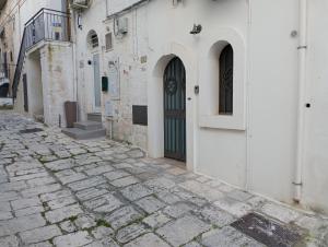 an alley with a door on a white building at Bombonera in Ostuni