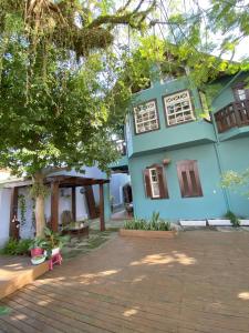 una casa azul con un árbol delante en Solar das Pétalas Guest House, en Florianópolis