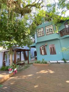a blue house with a tree in front of it at Solar das Pétalas Guest House in Florianópolis
