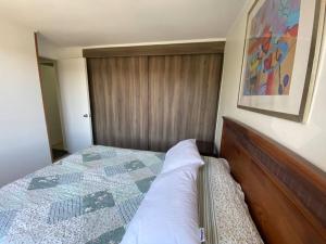 um quarto com uma cama com uma colcha em Acogedor dpto en puerto varas em Puerto Varas