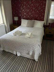 a bedroom with a large white bed with a red wall at Castle tavern pub&rooms in Richmond