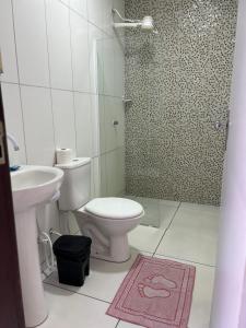a bathroom with a toilet and a sink and a shower at Casa Temporada Suítes in Maragogi