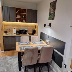 a dining room table with chairs and a kitchen at Regulus apartment Brzeće Kopaonik in Brzeće