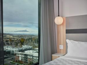 a bedroom with a view of a city at Alt Hotel Calgary University District in Calgary +38 photos